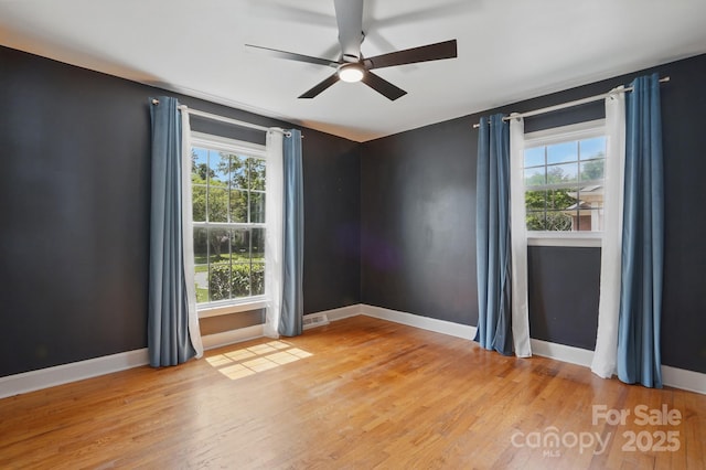 unfurnished room featuring a ceiling fan, light wood-style flooring, and a healthy amount of sunlight