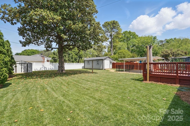 view of yard with a fenced backyard, an outbuilding, and a shed