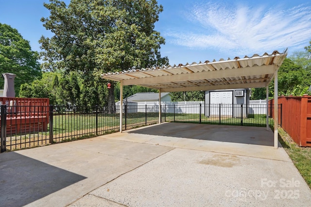 view of parking featuring concrete driveway, fence, and a detached carport