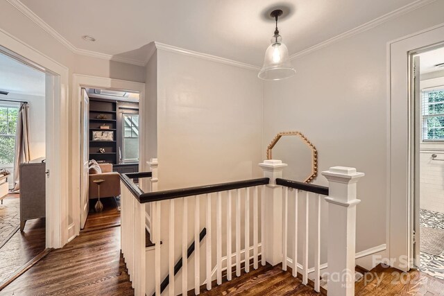 stairway featuring crown molding, baseboards, wood finished floors, and plenty of natural light