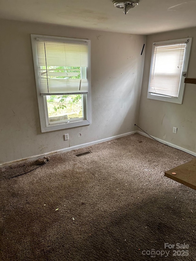 empty room with visible vents and carpet flooring