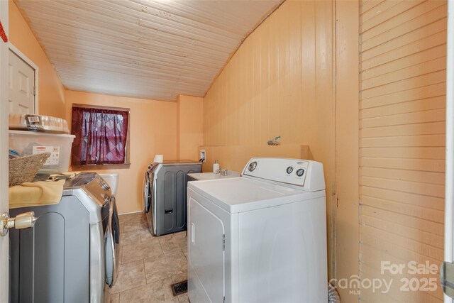 302 Charlotte St, York, SC 29745 - clothes washing area featuring separate washer and dryer, wood walls, and laundry area