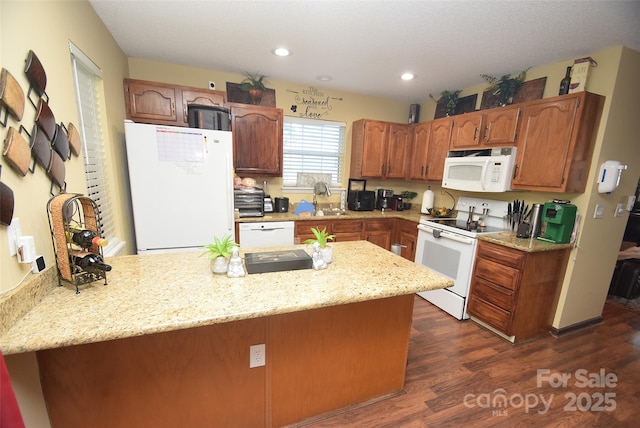 kitchen featuring a peninsula, white appliances, recessed lighting, and dark wood finished floors