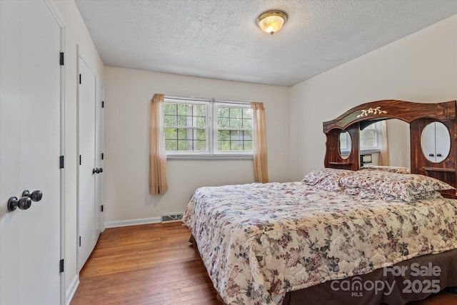 6443 Eaglecrest Rd, Charlotte, NC 28212 - bedroom featuring a textured ceiling, wood finished floors, visible vents, and baseboards