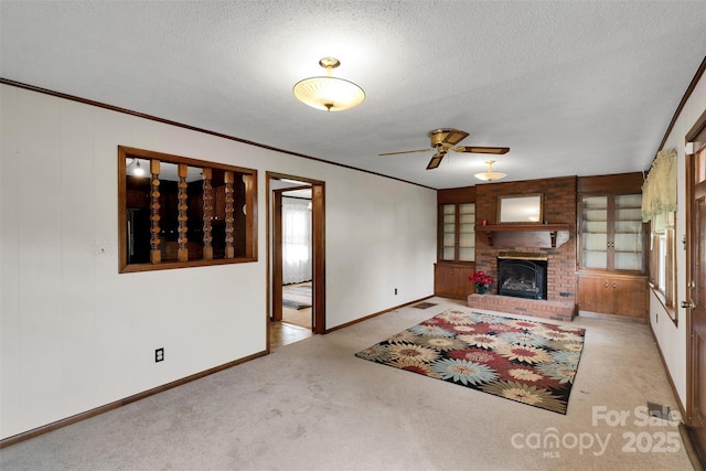 543 18th St NW, Hickory, NC 28601 - carpeted living room featuring baseboards, a ceiling fan, a textured ceiling, a fireplace, and crown molding