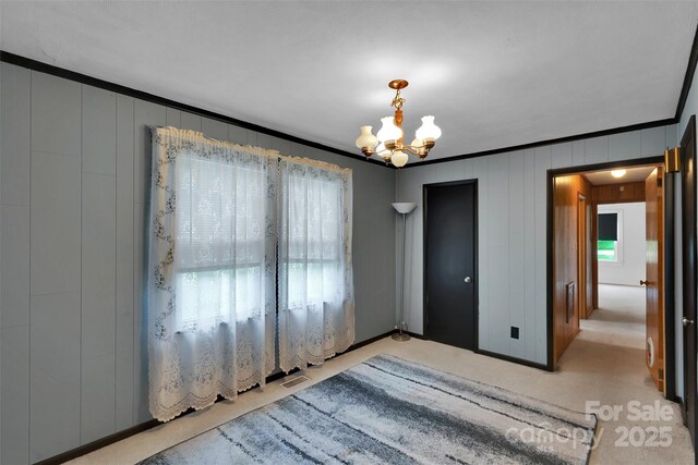 543 18th St NW, Hickory, NC 28601 - spare room featuring a chandelier, ornamental molding, a decorative wall, and carpet flooring