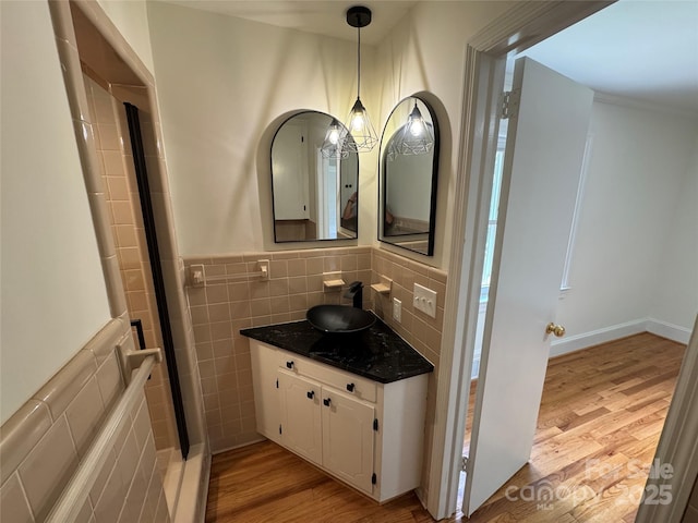 bathroom with tile walls, wood finished floors, and vanity