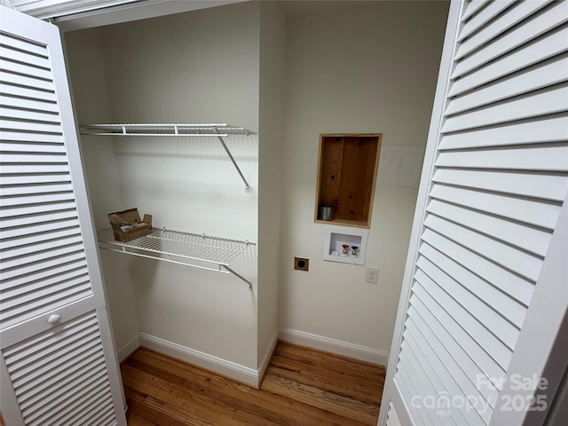 clothes washing area featuring baseboards, hookup for a washing machine, wood finished floors, electric dryer hookup, and laundry area