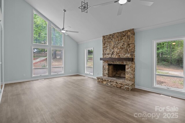 unfurnished living room featuring a healthy amount of sunlight, ornamental molding, baseboards, and ceiling fan