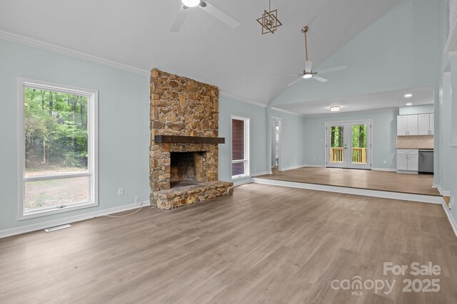 unfurnished living room with a healthy amount of sunlight, ceiling fan, and crown molding
