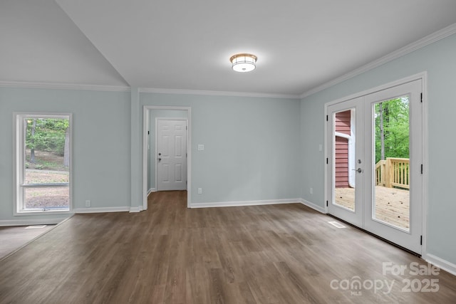 unfurnished room featuring plenty of natural light, wood finished floors, and ornamental molding
