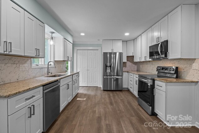 kitchen with dark wood-type flooring, white cabinetry, stainless steel appliances, and a sink