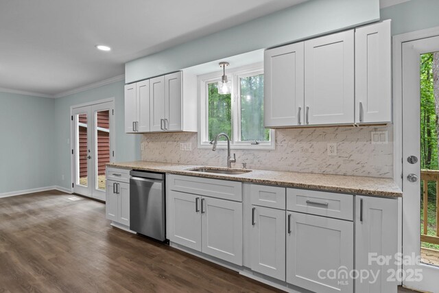 kitchen featuring backsplash, stainless steel dishwasher, crown molding, and a sink
