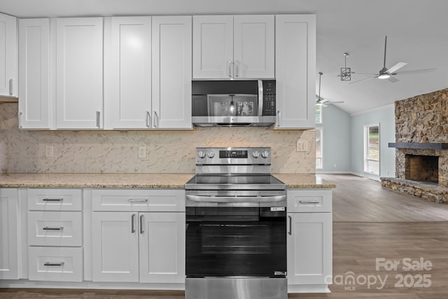 kitchen with a ceiling fan, decorative backsplash, appliances with stainless steel finishes, and white cabinetry