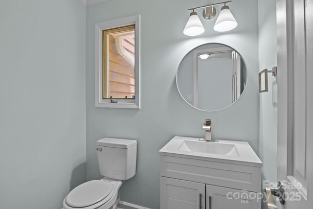 half bathroom featuring vanity and toilet