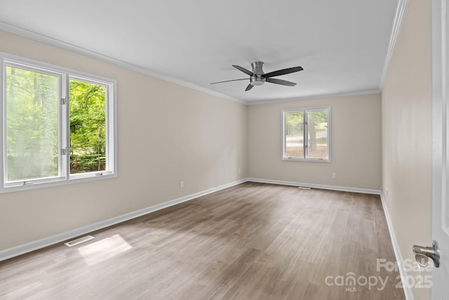 spare room featuring a wealth of natural light, ornamental molding, and visible vents