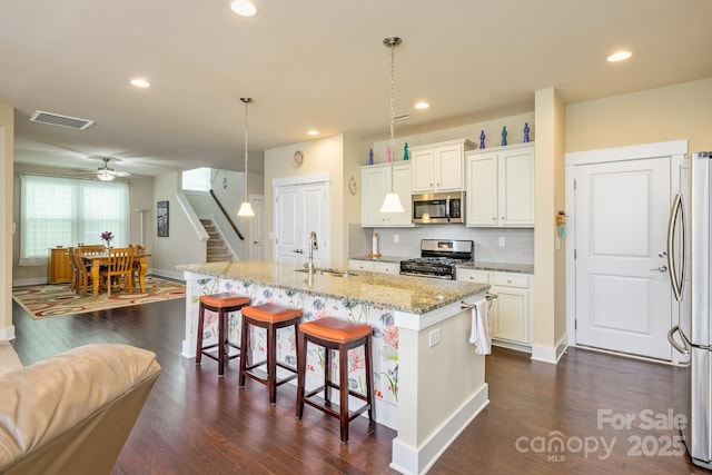 kitchen featuring appliances with stainless steel finishes, a sink, a ceiling fan, dark wood-type flooring, and recessed lighting