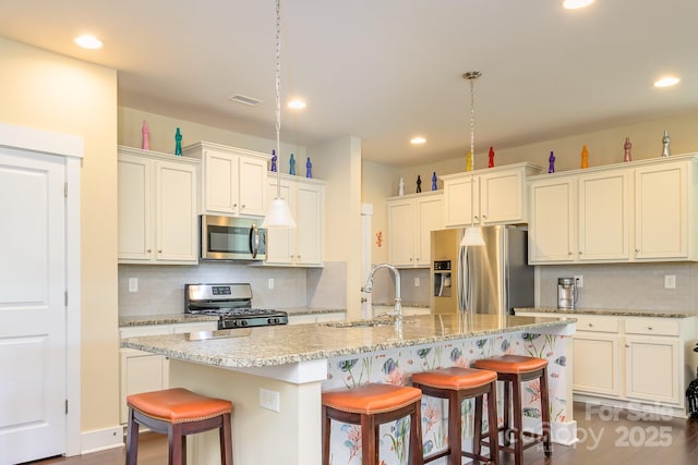 kitchen with stainless steel appliances, backsplash, a sink, a kitchen breakfast bar, and recessed lighting