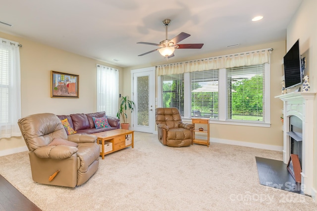 living area with plenty of natural light, a ceiling fan, a fireplace with flush hearth, baseboards, and recessed lighting