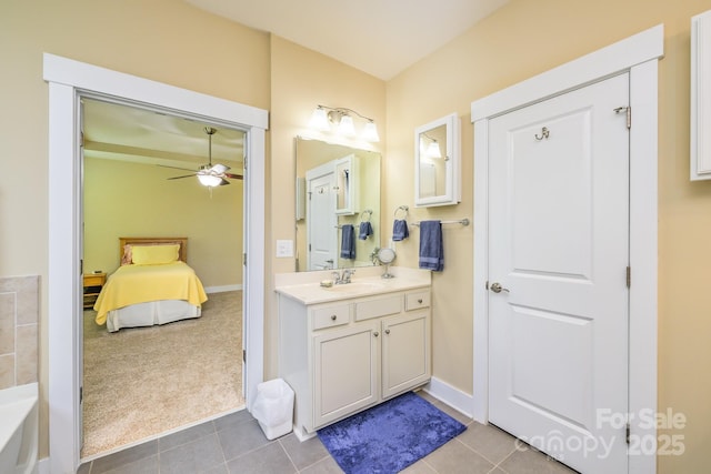 ensuite bathroom featuring a ceiling fan, tile patterned floors, vanity, and a bath