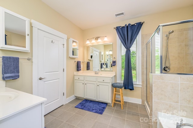 bathroom featuring a stall shower, vanity, tile patterned flooring, and baseboards