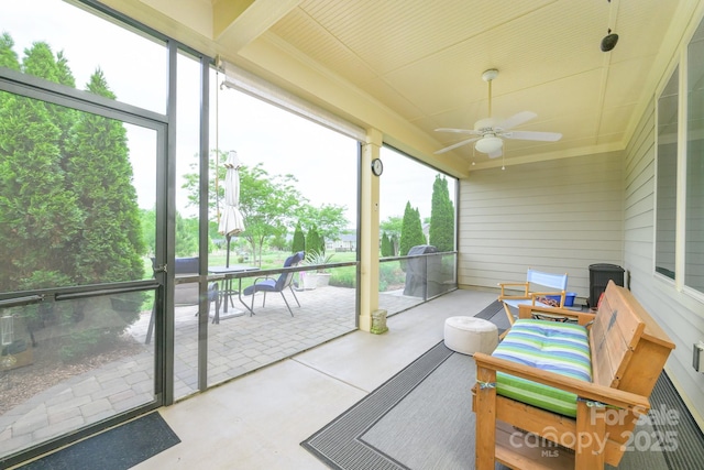 sunroom / solarium with ceiling fan and outdoor dining space
