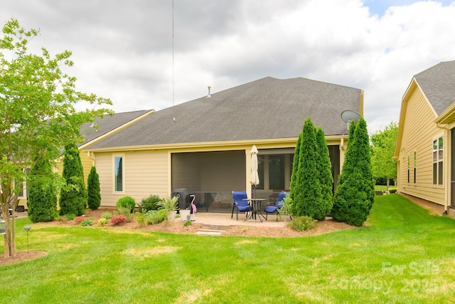 rear view of house with a patio and a lawn