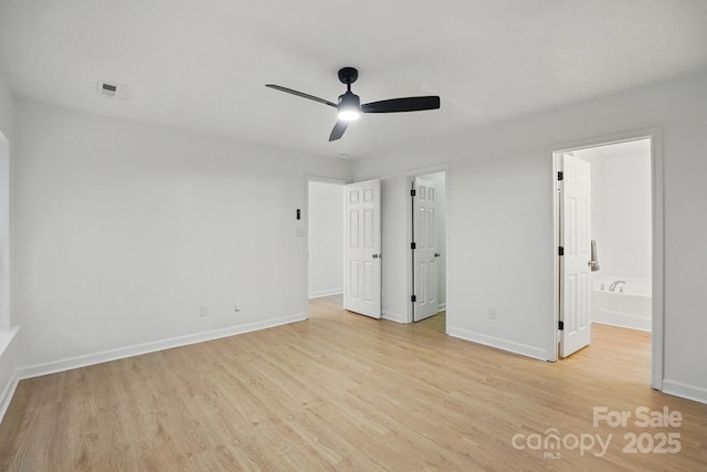 unfurnished bedroom with baseboards, ensuite bathroom, a ceiling fan, and light wood-style flooring