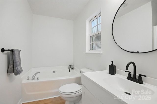 full bath featuring a garden tub, toilet, wood finished floors, and vanity