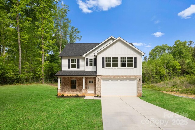 view of front of property with a front lawn, board and batten siding, an attached garage, driveway, and brick siding