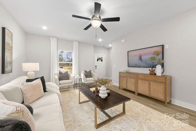 living room featuring recessed lighting, light wood finished floors, a ceiling fan, and baseboards