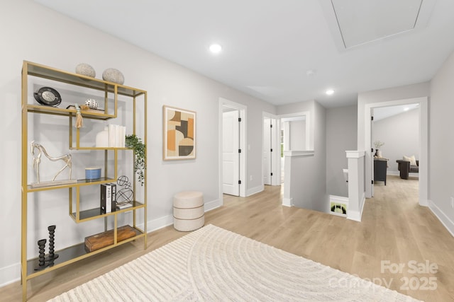 corridor featuring recessed lighting, wood finished floors, an upstairs landing, baseboards, and attic access
