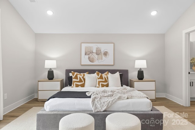 bedroom with baseboards, recessed lighting, and wood finished floors