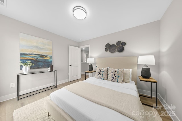 bedroom with baseboards and wood finished floors