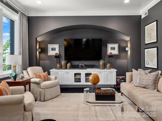 living room featuring arched walkways, recessed lighting, and crown molding