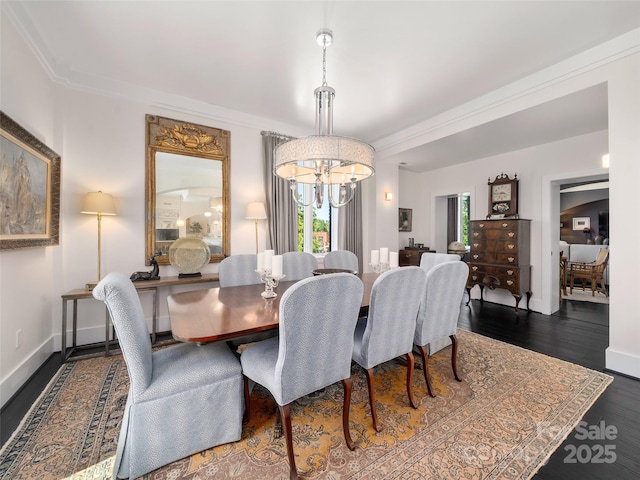 dining room with dark wood-style flooring, crown molding, baseboards, and a notable chandelier