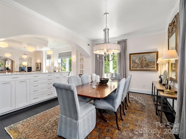 dining space featuring arched walkways, plenty of natural light, and ornamental molding