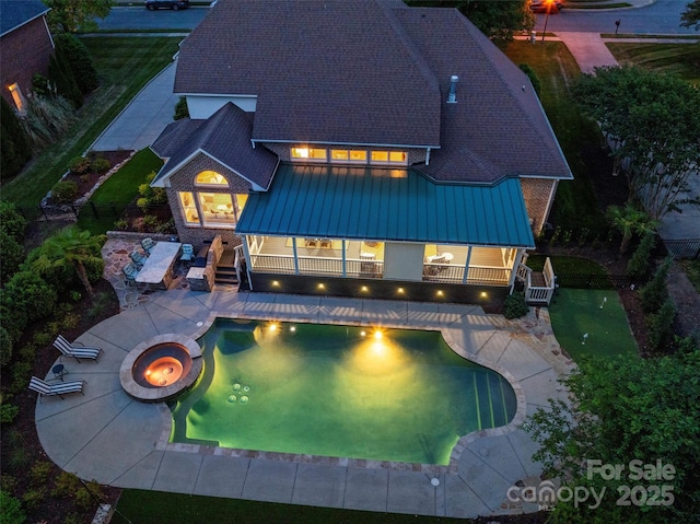 back of property with metal roof, a shingled roof, a fenced backyard, a patio area, and a standing seam roof