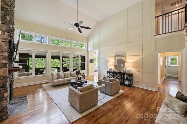 living room featuring ceiling fan, visible vents, high vaulted ceiling, and wood finished floors