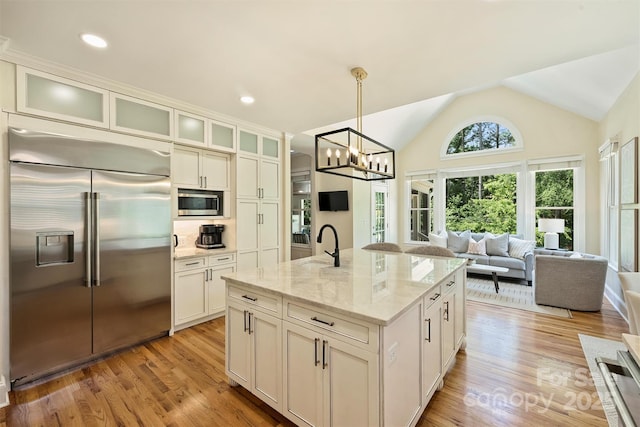 kitchen featuring stainless steel appliances, open floor plan, light wood-type flooring, and a chandelier