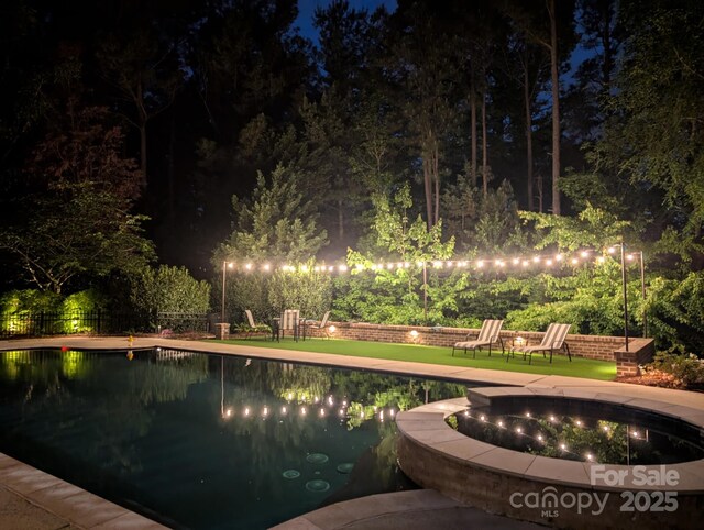 pool at night with fence and a fenced in pool