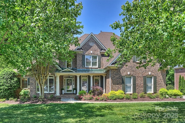 craftsman inspired home with a front yard, brick siding, and covered porch