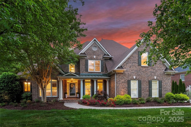 traditional-style house with brick siding and a front yard