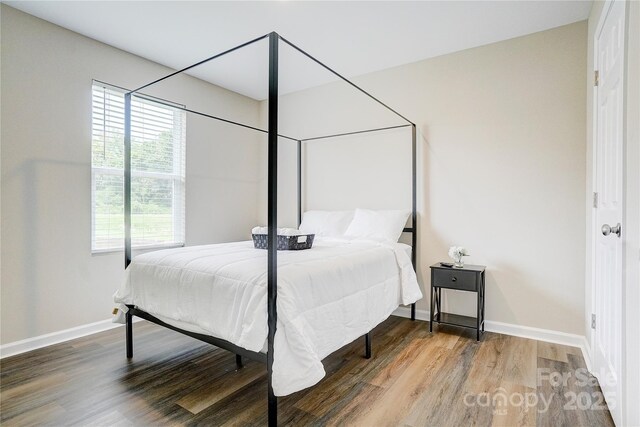 bedroom featuring baseboards and wood finished floors