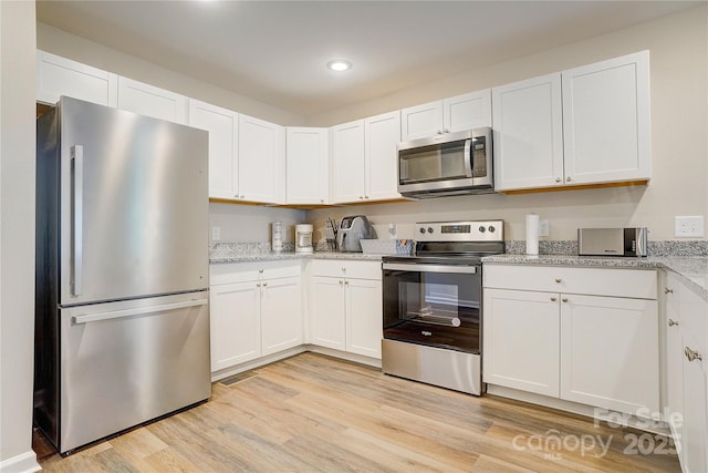809 Fisher St, Concord, NC 28027 - kitchen featuring appliances with stainless steel finishes, light wood finished floors, white cabinets, recessed lighting, and light stone counters