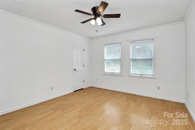 spare room with ornamental molding, baseboards, light wood-style flooring, and a ceiling fan