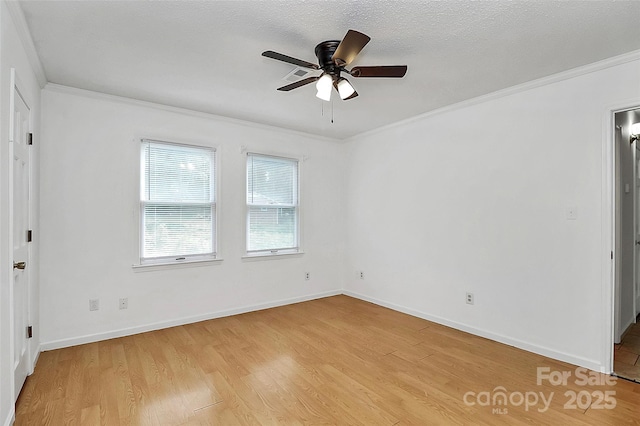 empty room featuring ceiling fan, ornamental molding, baseboards, and light wood-style flooring