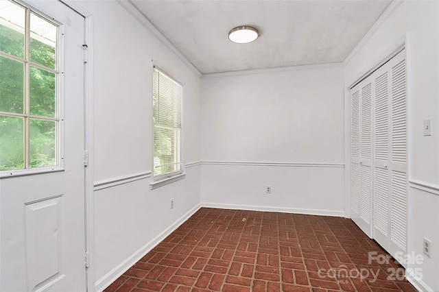 interior space with crown molding, brick patterned floor, and a closet