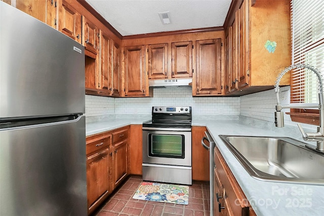 kitchen featuring under cabinet range hood, brown cabinetry, visible vents, tasteful backsplash, and appliances with stainless steel finishes