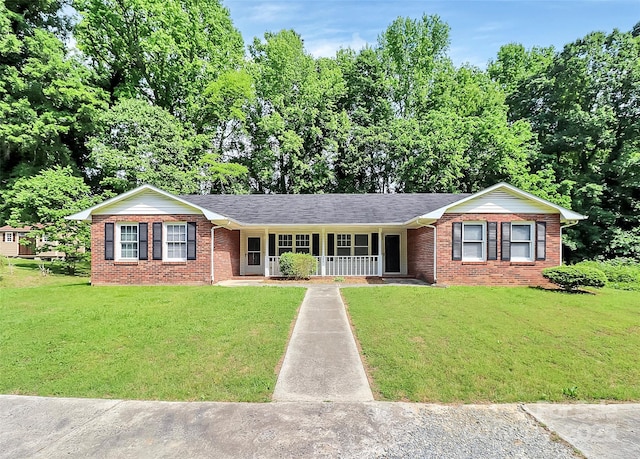 ranch-style home with a front yard, brick siding, and covered porch